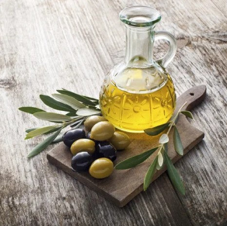 Bottle of high-phenolic extra virgin olive oil beside fresh olives, representing olive oil for dementia and cognitive decline