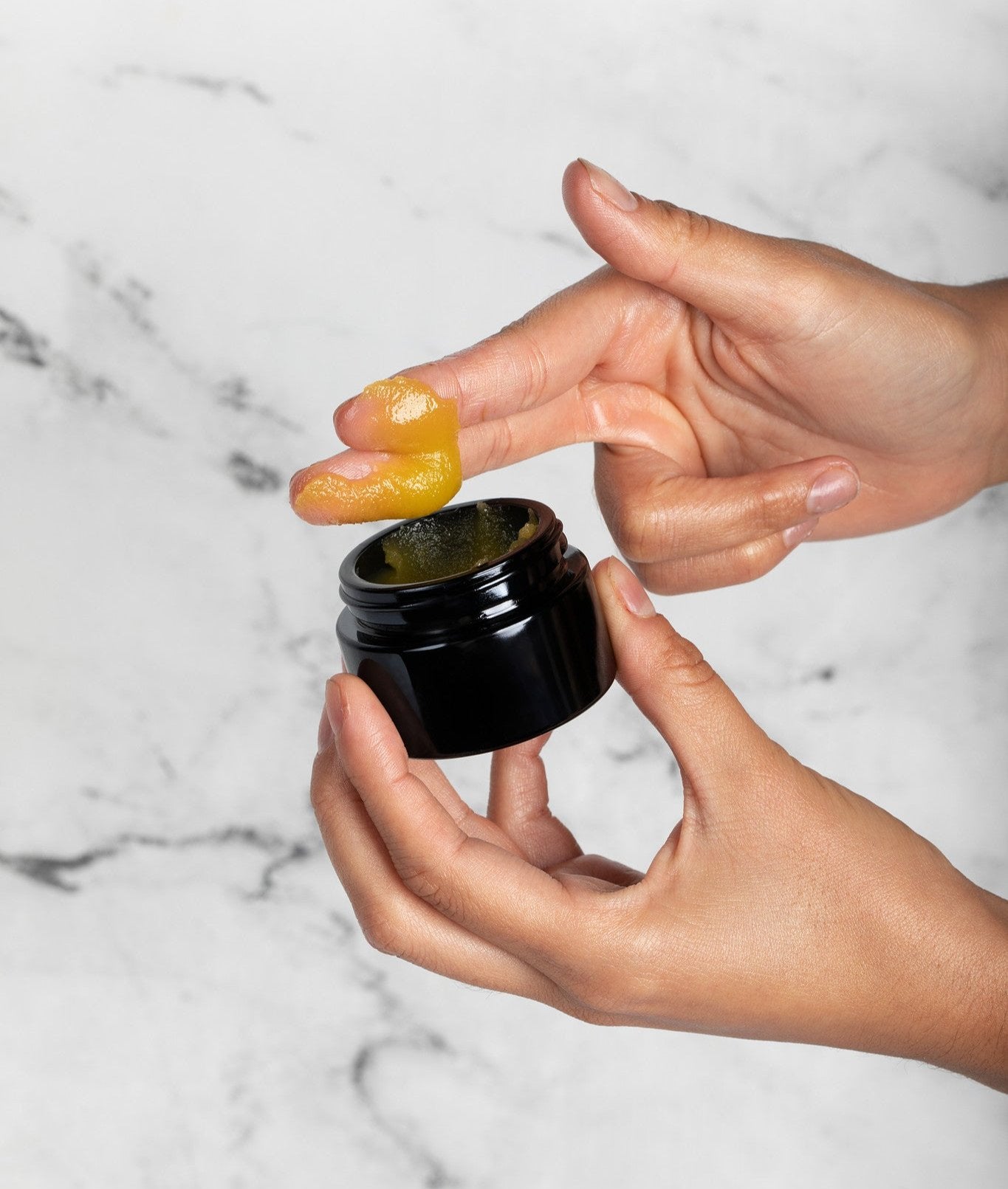 Applying olive oil and beeswax balm to nourish dry skin